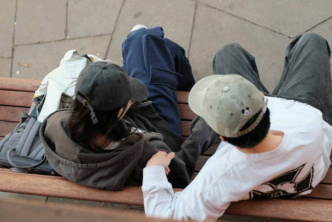 Two Brazilian friends having a warm conversation on a park bench