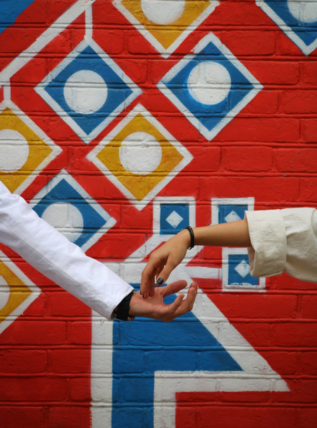 Two Brazilian colleagues shaking hands warmly in an office